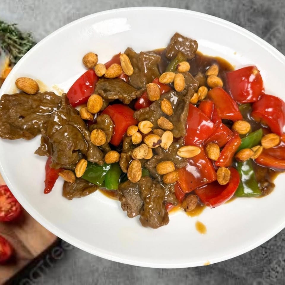 Kung Pao beef with red and green bell peppers, peanuts, and a rich brown sauce.