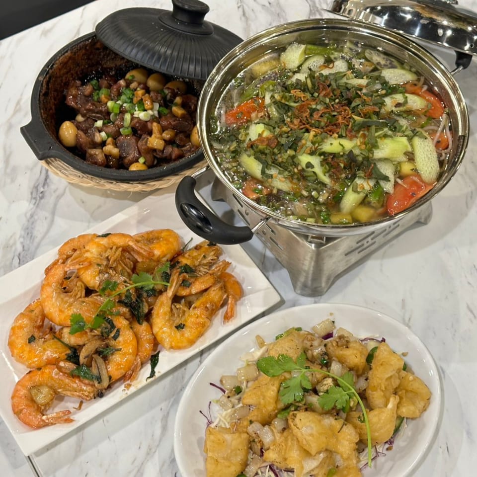 A Chinese feast featuring a hot pot, clay pot stew, fried shrimp, and crispy tofu.