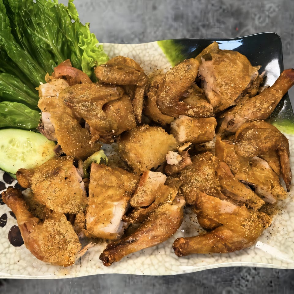 Platter of Kin's Restaurant's crispy fried chicken pieces, garnished with lettuce and cucumber slices.